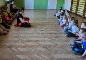 Dzieci słuchają opowieści o pracy ratownika medycznego.