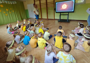 Dzieci oglądają krótki film edukacyjny o słońcu.