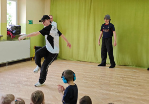 Dzieci oglądają pokaz taneczny breakdance.