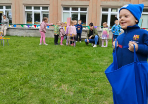 Dziecko pokonuje tor przeszkód, skacząc w worku.