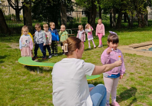 Dziecko przeszło po równoważni i puszcza bańki mydlane.