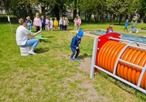 Dziecko przechodzi po równoważni i będzie puszczać bańki mydlane.