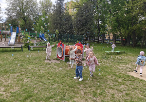 Dzieci łapia banki mydlane.