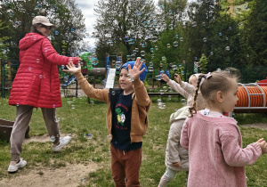 Dzieci łapia banki mydlane.