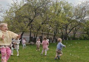 Dzieci łapia banki mydlane.