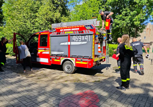 Strażacy zabezpieczają hydronetki na wozie strażackim.