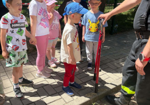 Dzieci poznają wyposażenie wozu strażackiego.
