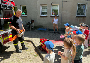 Dzieci poznają wyposażenie wozu strażackiego.