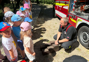 Dzieci poznają wyposażenie wozu strażackiego.