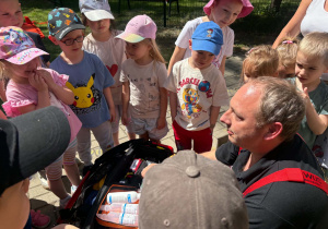Dzieci poznają wyposażenie wozu strażackiego.