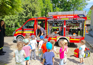Dzieci zwiedzają wóz strażacki w środku.