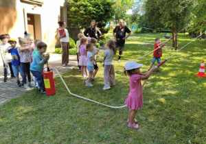 Dzieci biorą udział w spotkaniu ze strażakami.