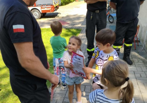 Dzieci biorą udział w spotkaniu ze strażakami.