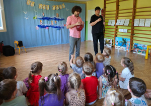 Dzieci słuchają dźwięków wygrywanych na oboju i balonie.