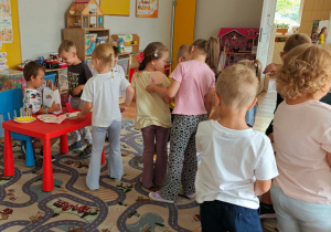 Dzieci wręczają jubilatowi laurki.