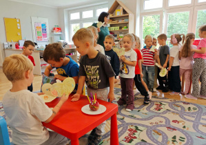 Dzieci wręczają jubilatowi urodzinowe laurki.