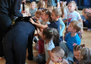 Dzieci integrują się z kotem, głaszcząc go.