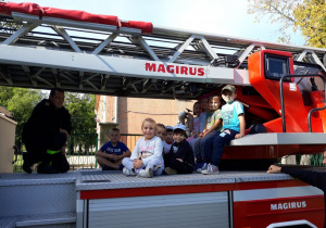 Dzieci z grupy II siedzą na wozie strażackim