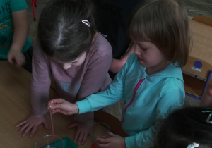 Dzieci z gr. II podczas eksperymentu "Kolorowe bąbelki"